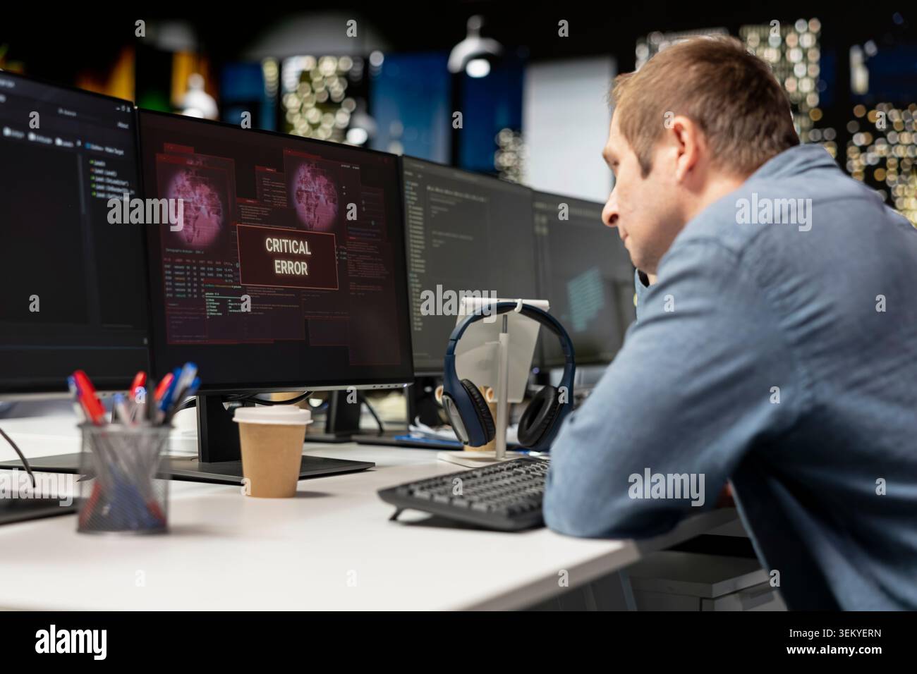 Programmer in startup office struggling to fix application errors while coding. IT professional dealing with computer bugs while coding in software development agency workplace Stock Photo