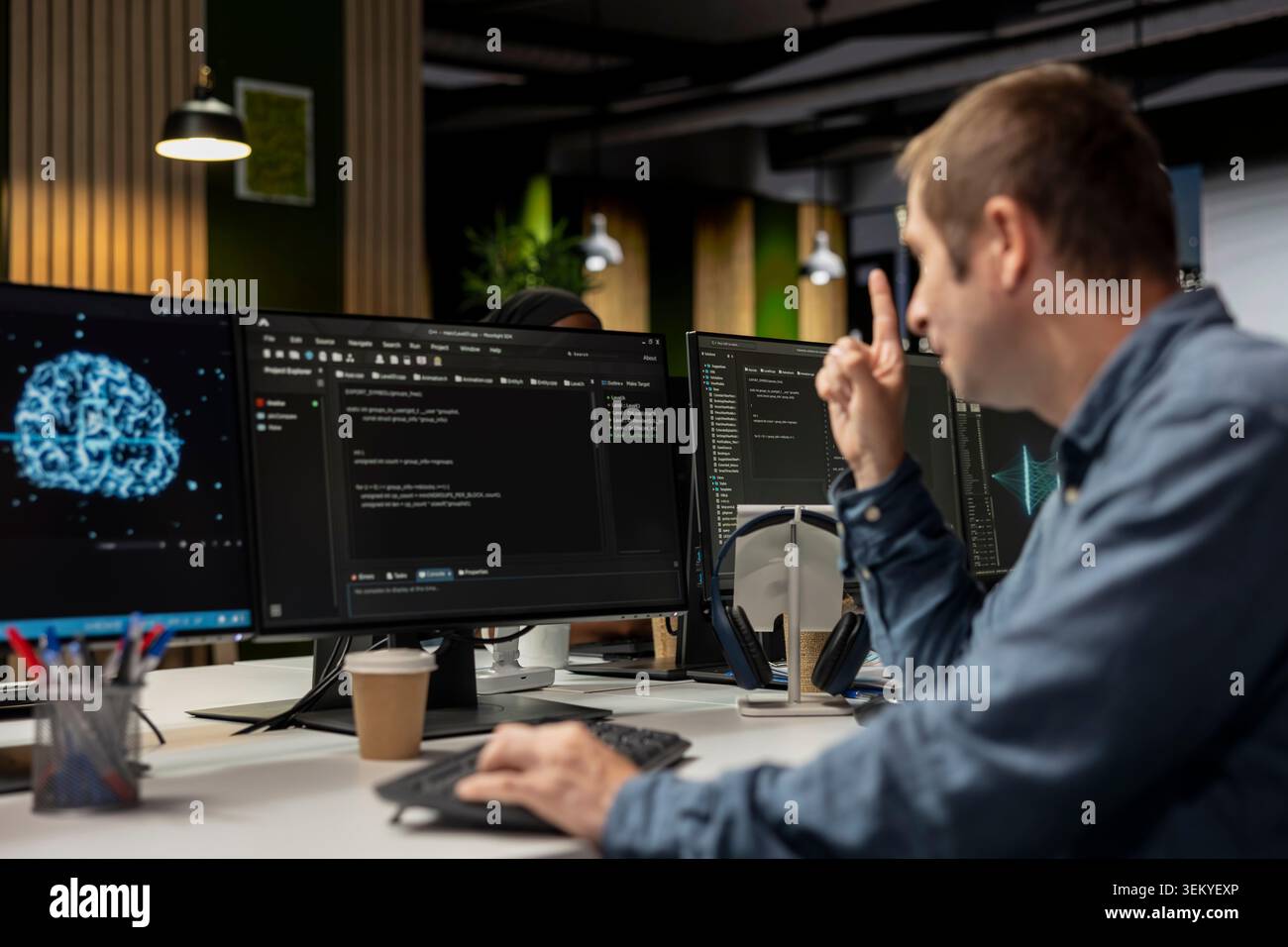System administrator using computer in tech startup office to develop programs using AI automation. IT expert working on PC, debugging applications with artificial intelligence deep learning Stock Photo