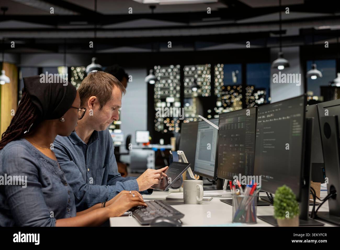 Manager assisting tech startup engineer coding advanced neural network algorithms during internship. Team leader helping african american trainee in office using deep learning models to do automation Stock Photo