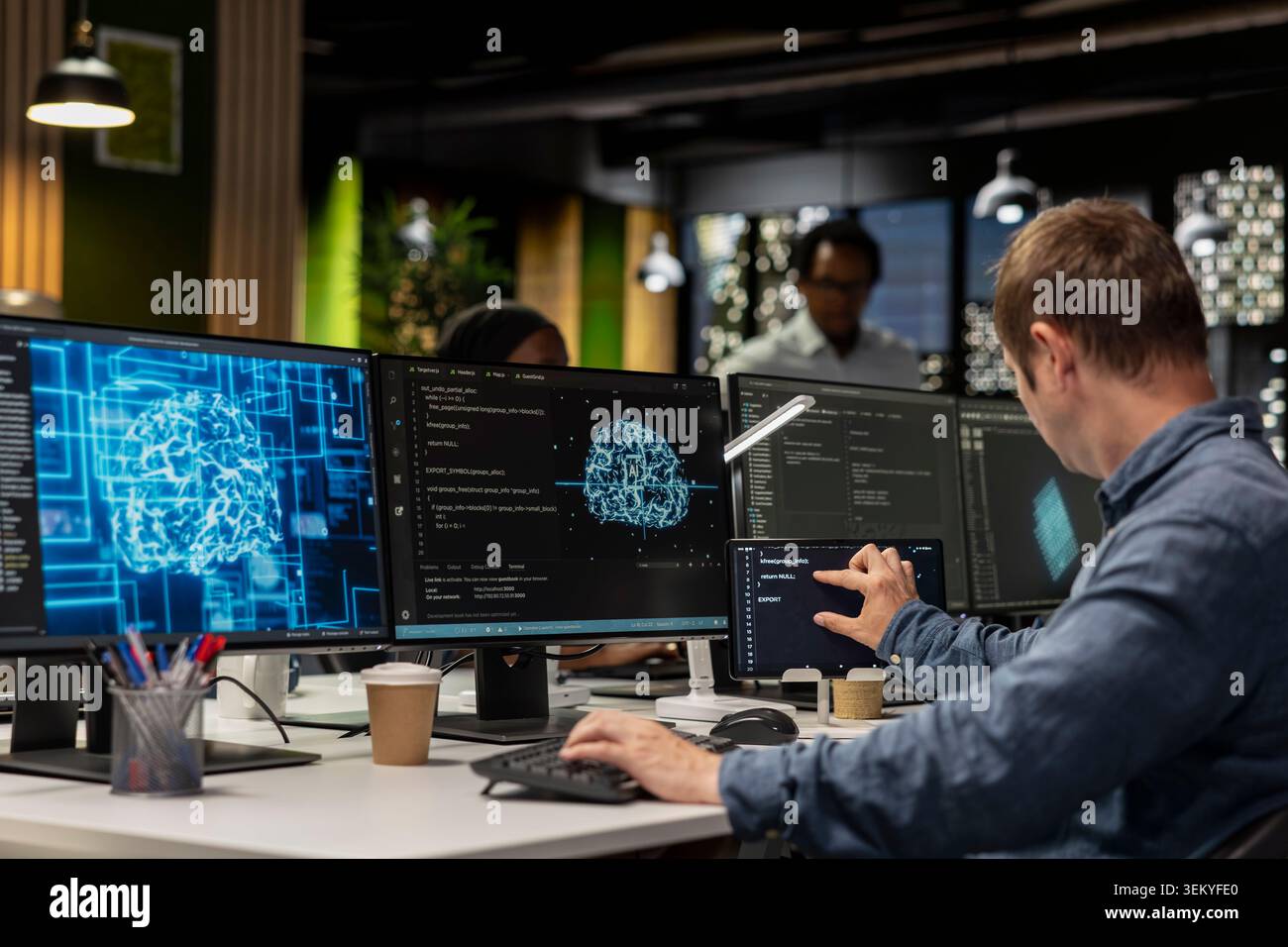 System administrator utilizing AI on PC to optimize performance and forecast issues. Tech company office worker training machine learning models to perform automatic updates Stock Photo