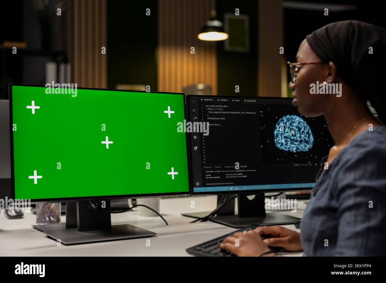 Programmer in tech startup office developing apps using AI automation on green screen PC. IT expert working on chroma key computer, debugging applications with artificial intelligence Stock Photo