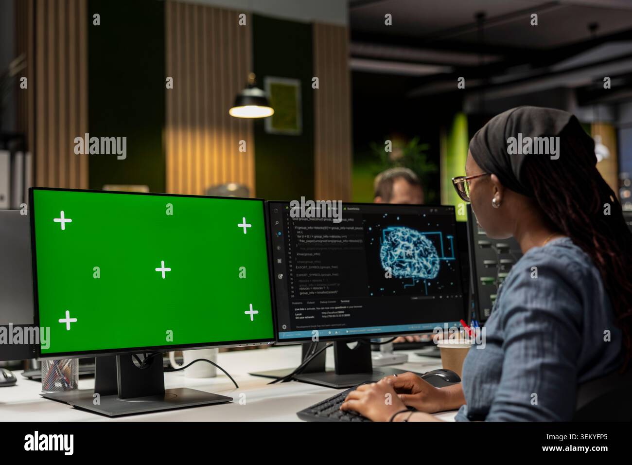 Programmer utilizing AI software on green screen PC to optimize performance and forecast issues. IT specialist in tech startup office training machine learning models using chroma key computer Stock Photo