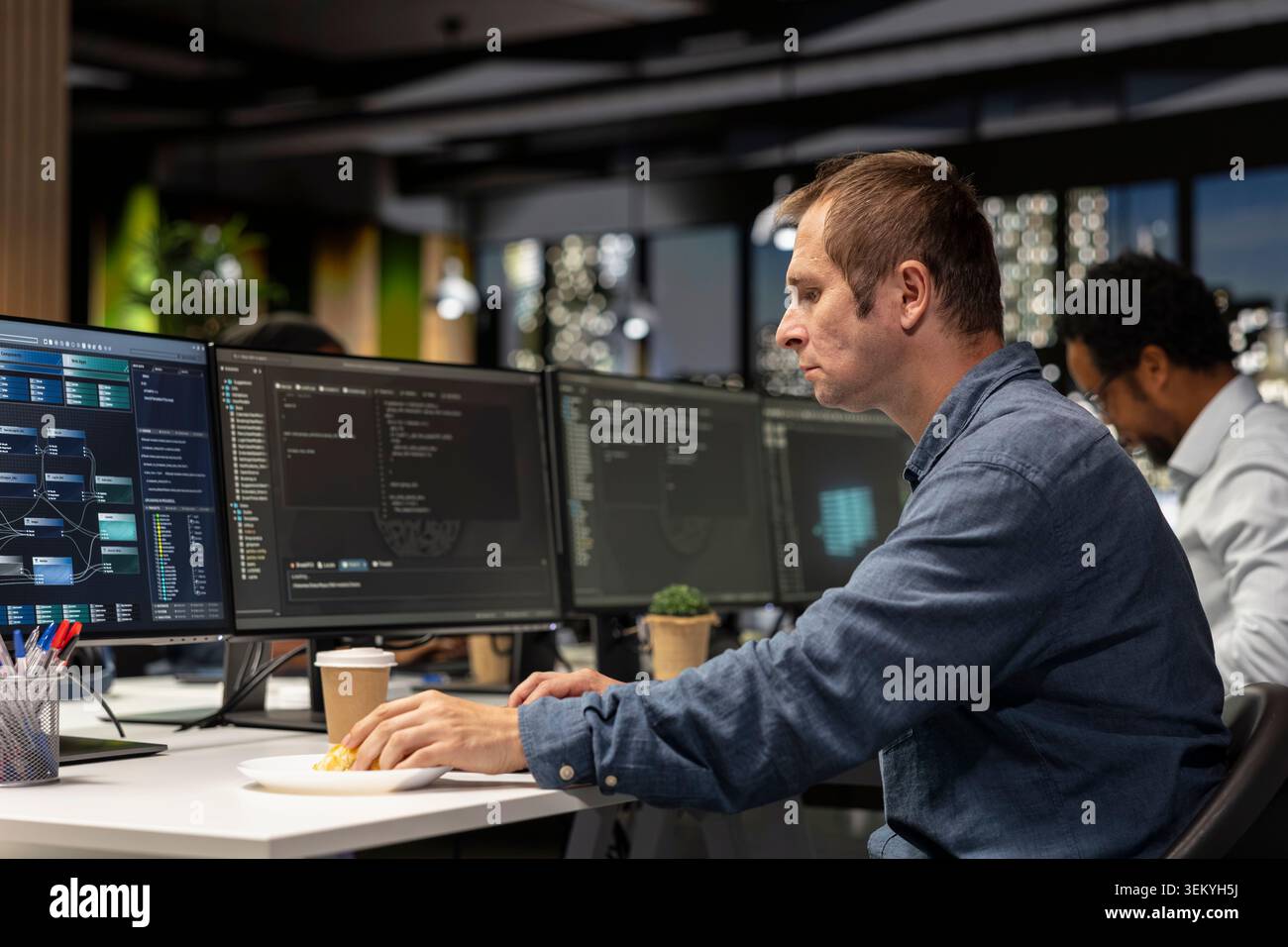 Software developer writing code, developing machine learning APIs. IT professional in tech startup working to troubleshoot software errors using artificial intelligence, resolving system crashes Stock Photo