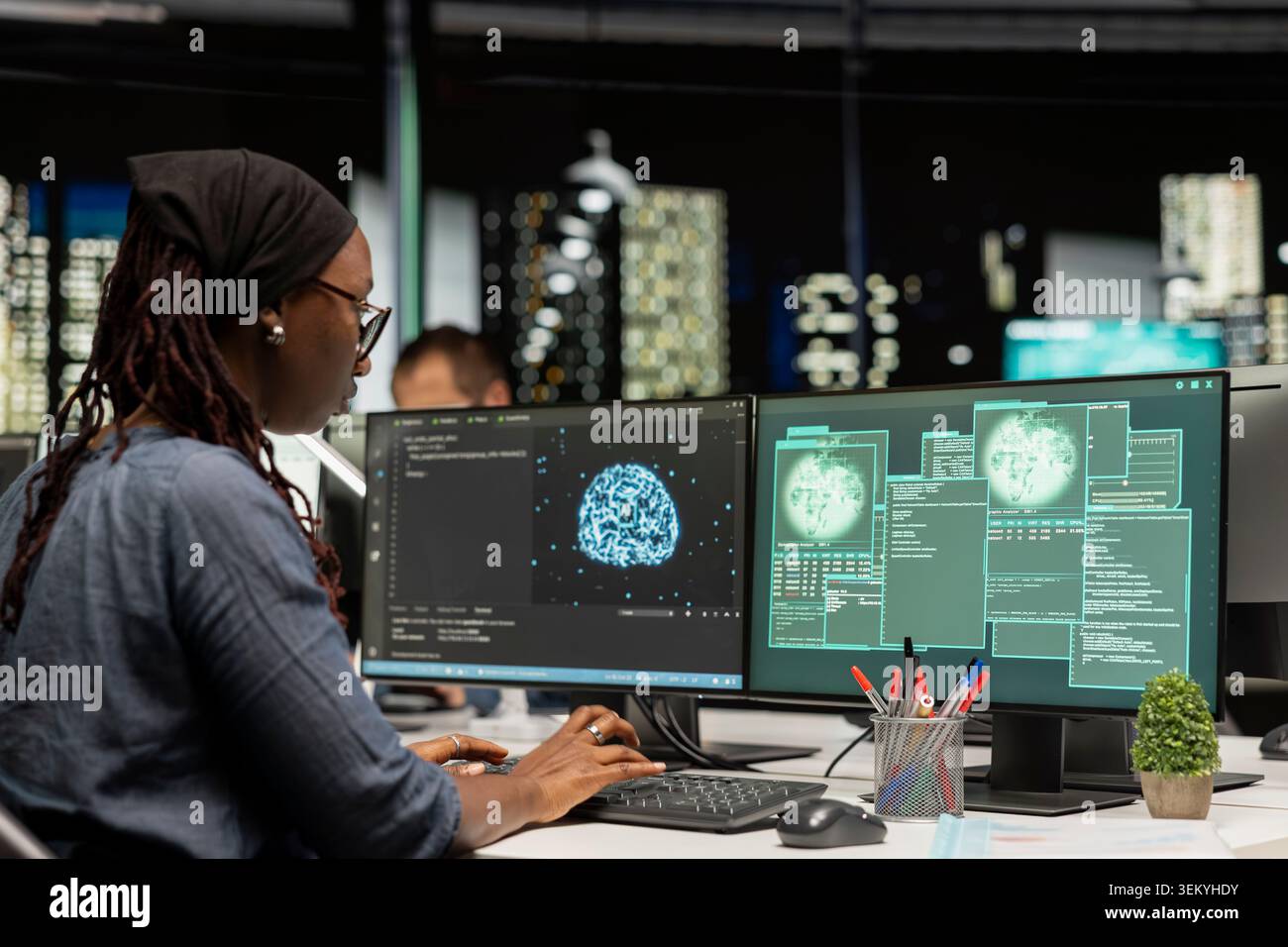 Software developer at office desk doing maintenance on computer systems using AI. African american woman in tech startup preventing issues bug affecting server networks using artificial intelligence Stock Photo