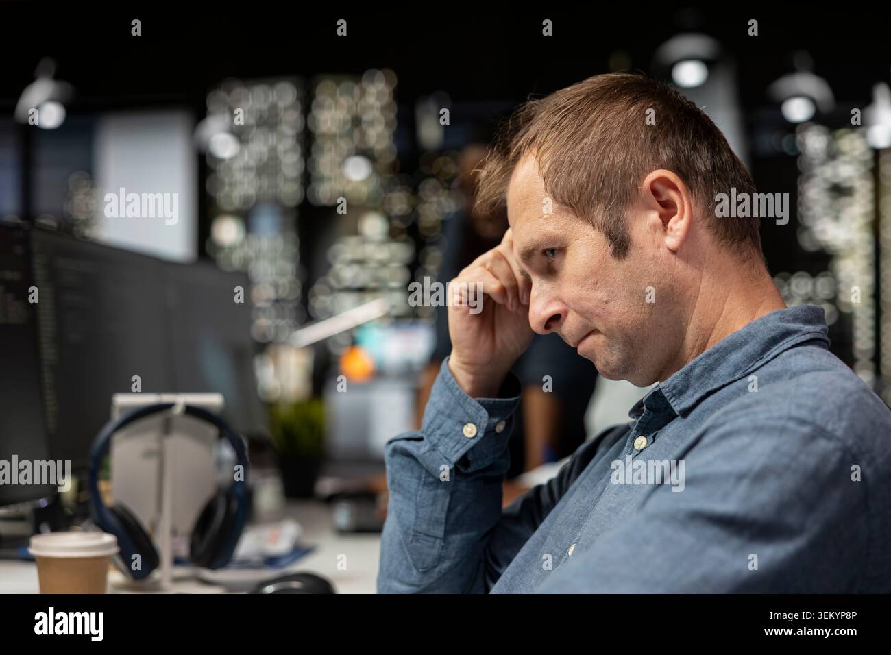 Close up of dejected man in startup office bummed after noticing error in code while doing quality assurance. Glum IT worker frowning, concerned by glitches in programming language Stock Photo