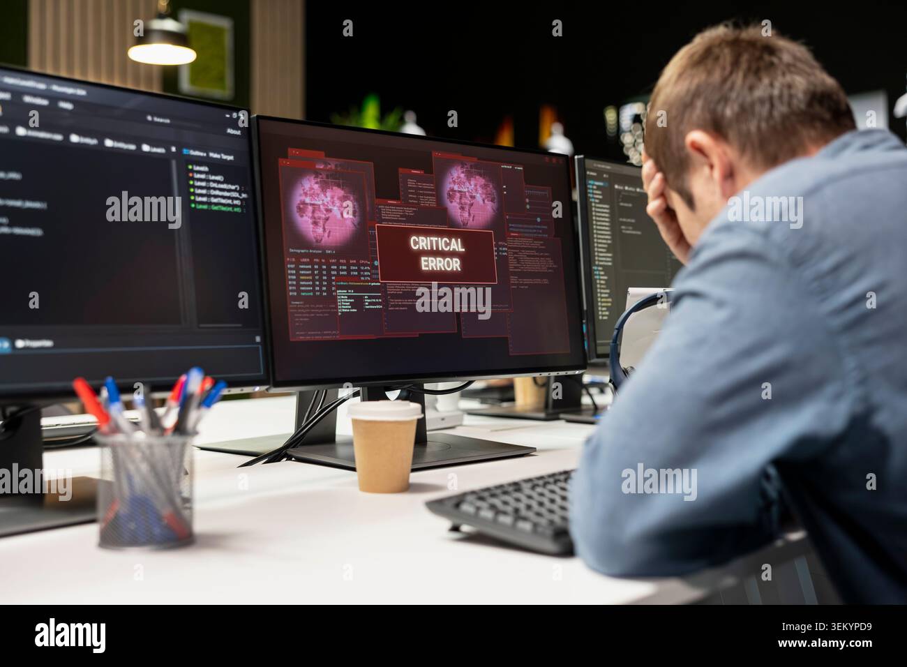 Engineer in startup office doing facepalm, worried after struggling to fix application errors while coding. Distressed IT worker troubled by computer bugs while coding in software development agency Stock Photo