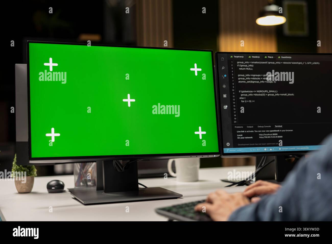 Engineer writing code on green screen PC, developing machine learning APIs. IT professional troubleshooting software errors using chroma key computer, resolving system crashes Stock Photo