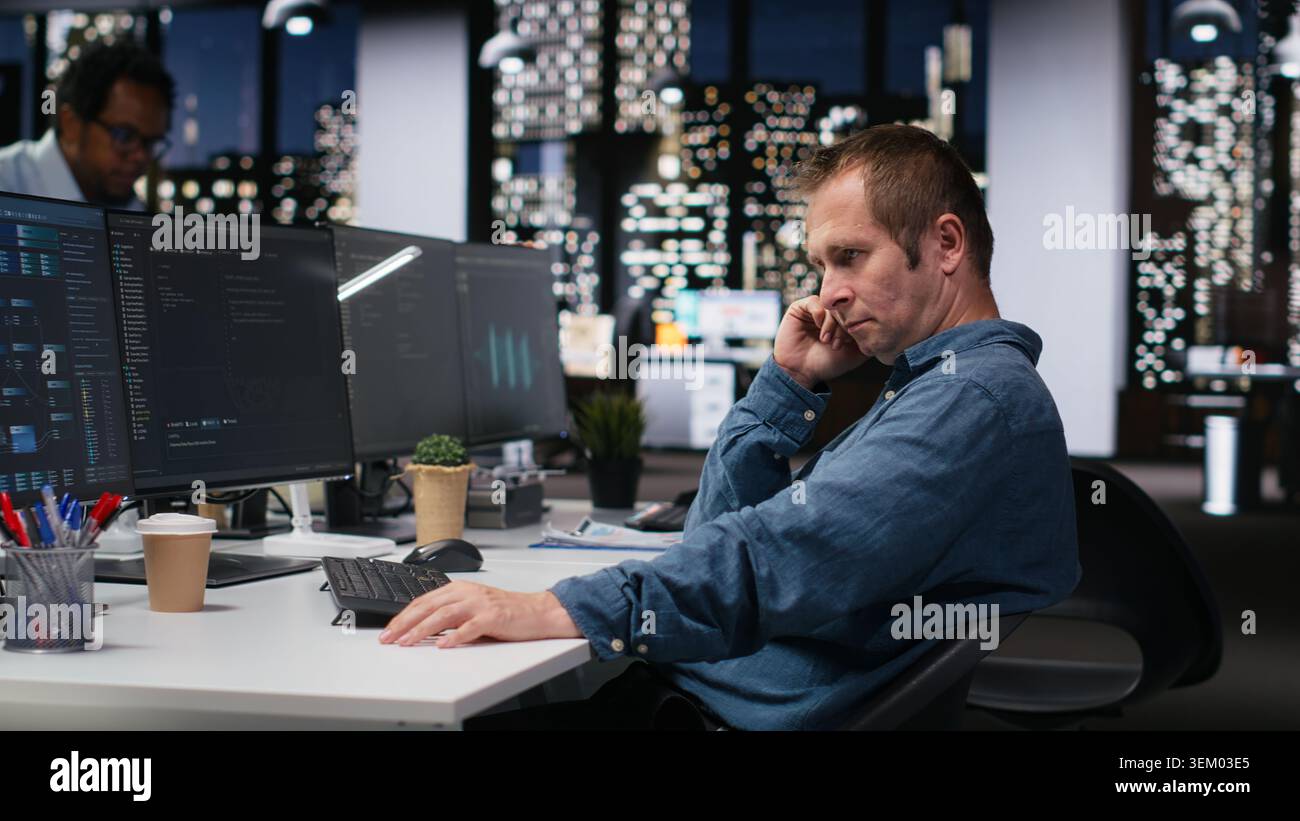 Admin in office waiting for code to finish compiling, developing machine learning models to automate tasks. Impatient startup worker bored while writing programming language scripts on PC Stock Photo
