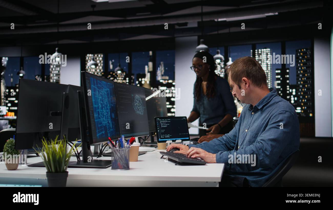 Tech agency system administrator using AI to optimize software performance in office late at night. IT expert at work using artificial intelligence to analyze code and do debugging Stock Photo