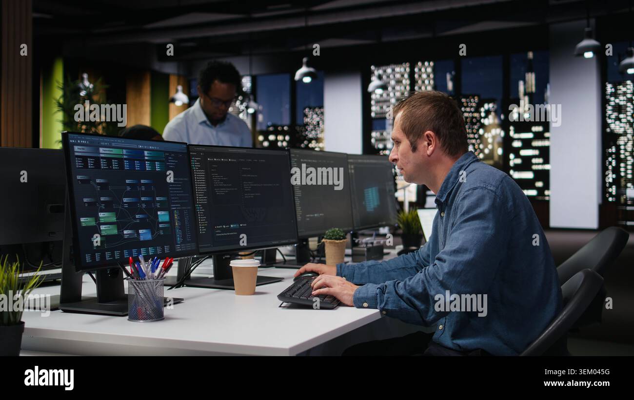 Programmer typing complex code on computer, developing machine learning models to automate business tasks in workspace. Developer writing programming language scripts on PC Stock Photo
