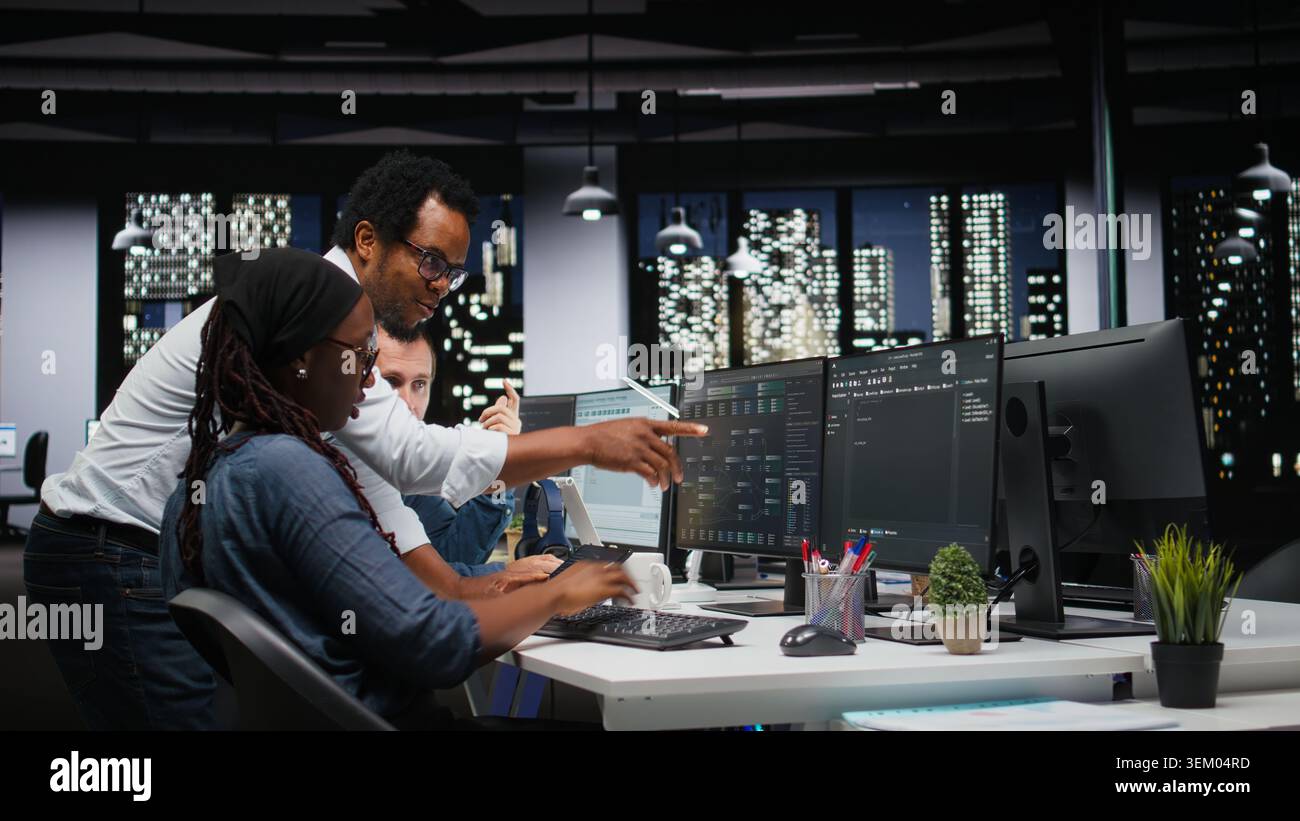 Technicians using PC in office, working with AI programming languages. Coworkers using computer in company workplace to do artificial intelligence tech quality assurance Stock Photo