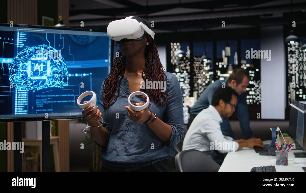 Developer in office using VR headset gear to analyze machine learning algorithms. IT expert uses virtual reality equipment to improve artificial intelligence prediction accuracy Stock Photo