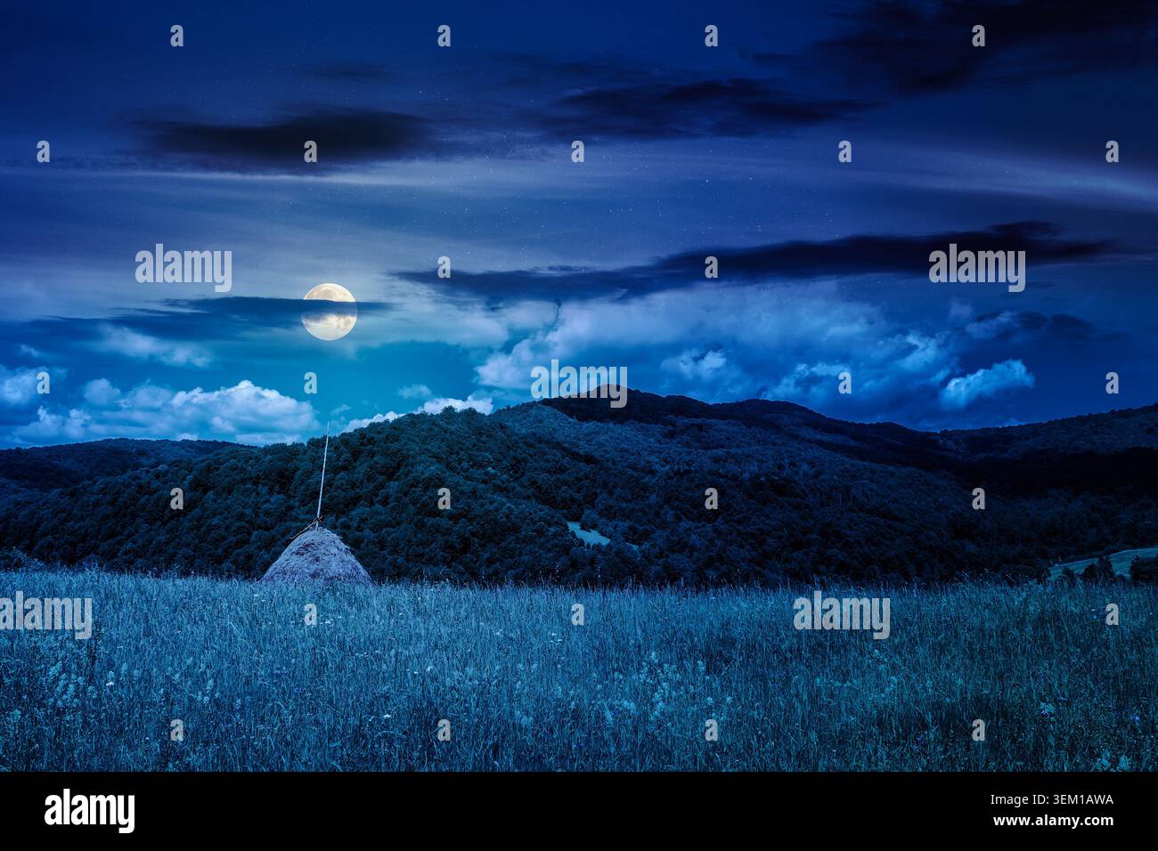 rural fields near pikui mountain in summertime at night. full moon over beautiful view of agricultural area. gorgeous mountain ridge with haystack on Stock Photo