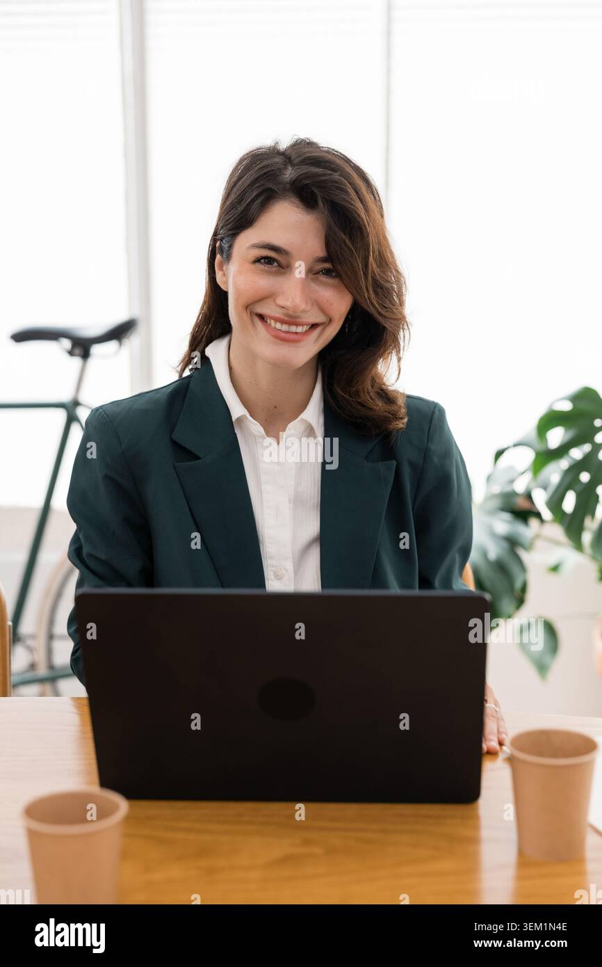 Professional woman smiling working on laptop Stock Photo