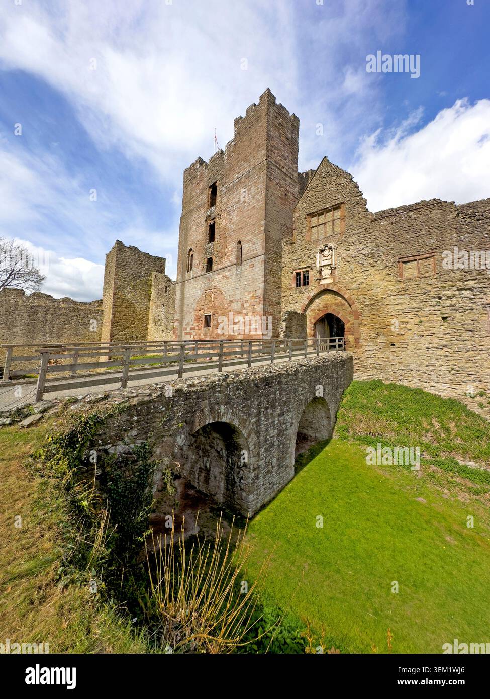 Wide-angle view of Ludlow Castle’s medieval Great Tower, stone bridge and inner bailey beneath a dramatic Shropshire sky Stock Photo