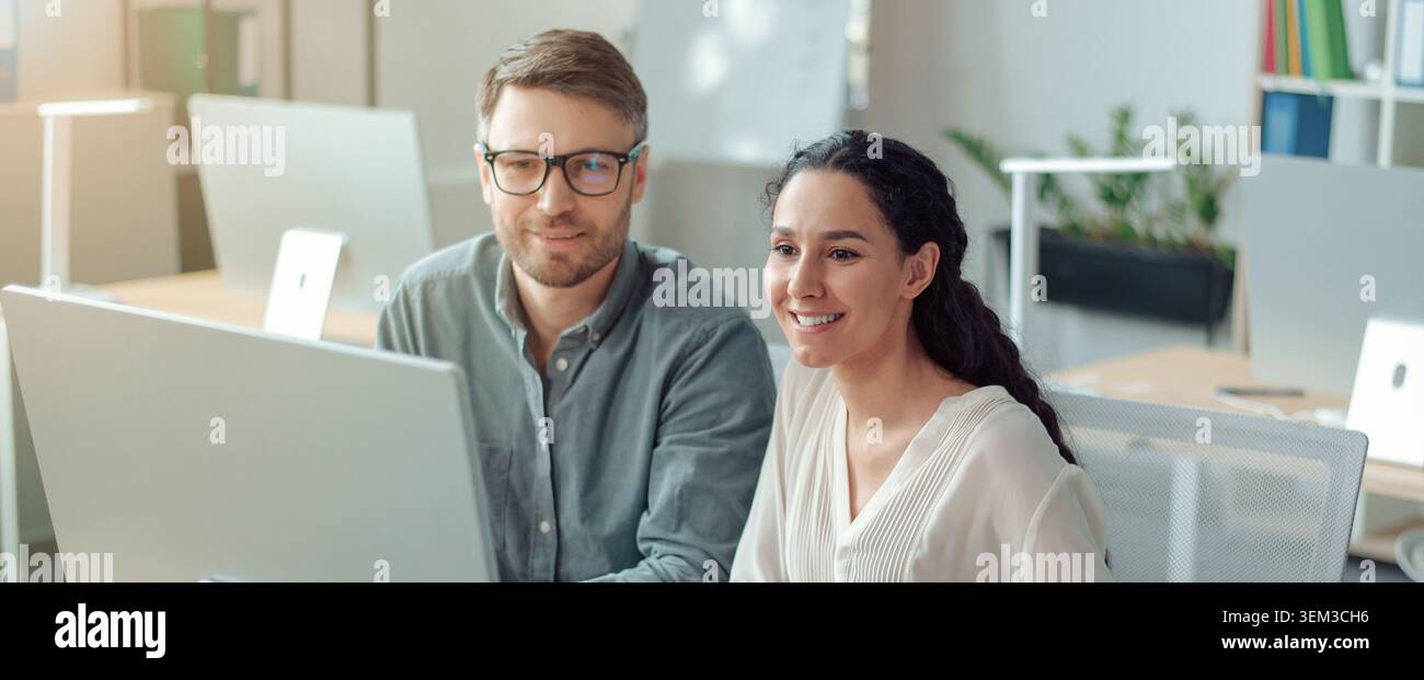 Two Professionals Working Together In Modern Office, Smiling And Engaged, Business Concept Stock Photo