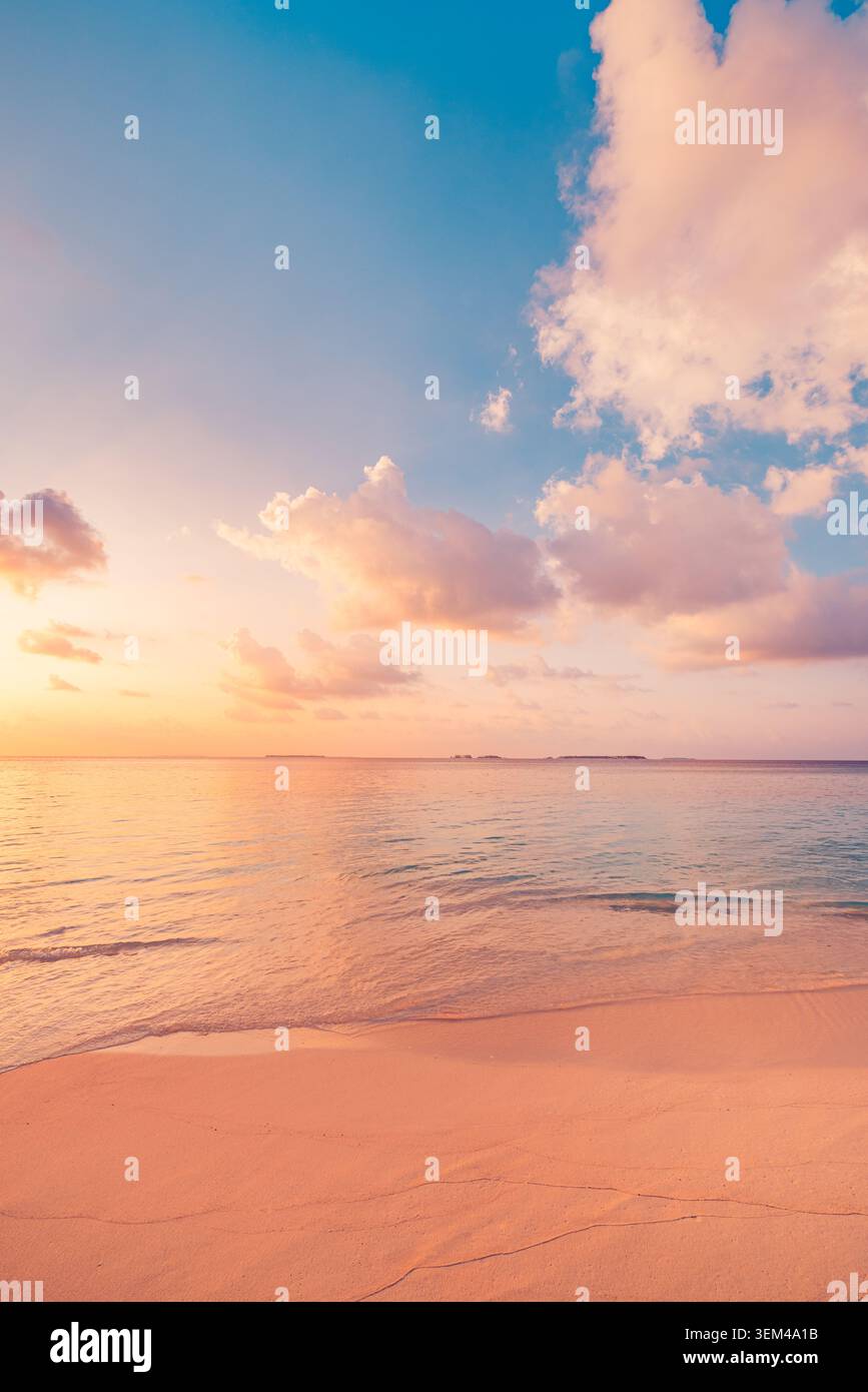 Gentle waves on empty beach at pastel dusk vertical frame, soft evening colors over tranquil sea, serene minimal tropical shore scene scenic. Wellness Stock Photo