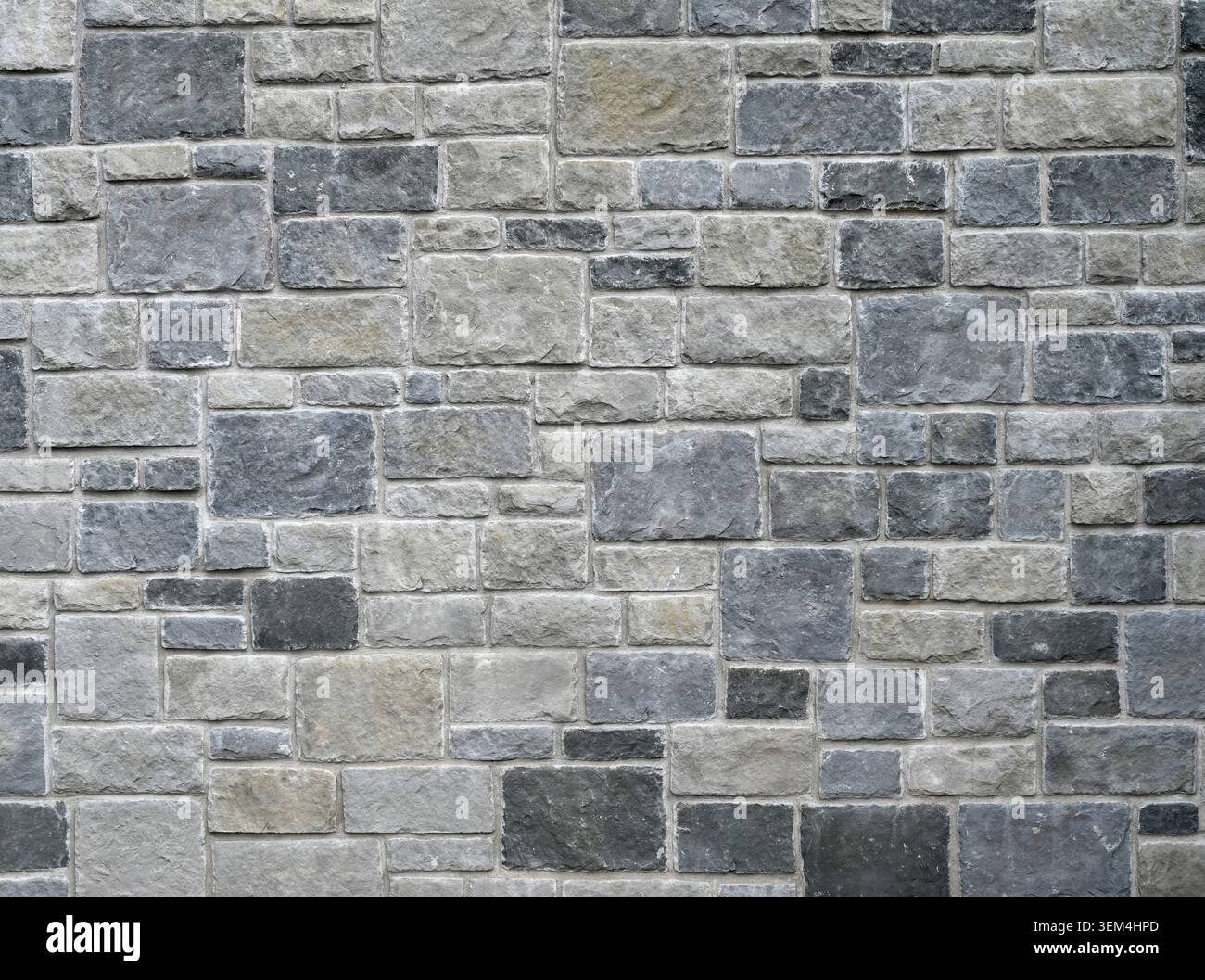 Horizontal close up of a rock wall and mortar surface with rectangular and square gray stone blocks in varied sizes Stock Photo