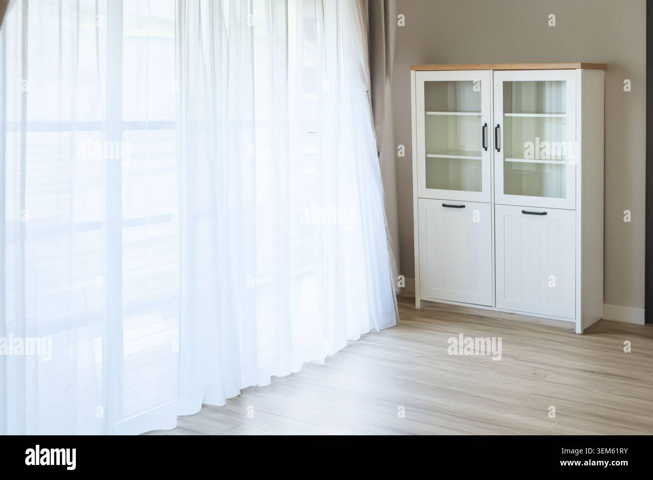 White bookcase with black handles in a room, close-up. Stock Photo