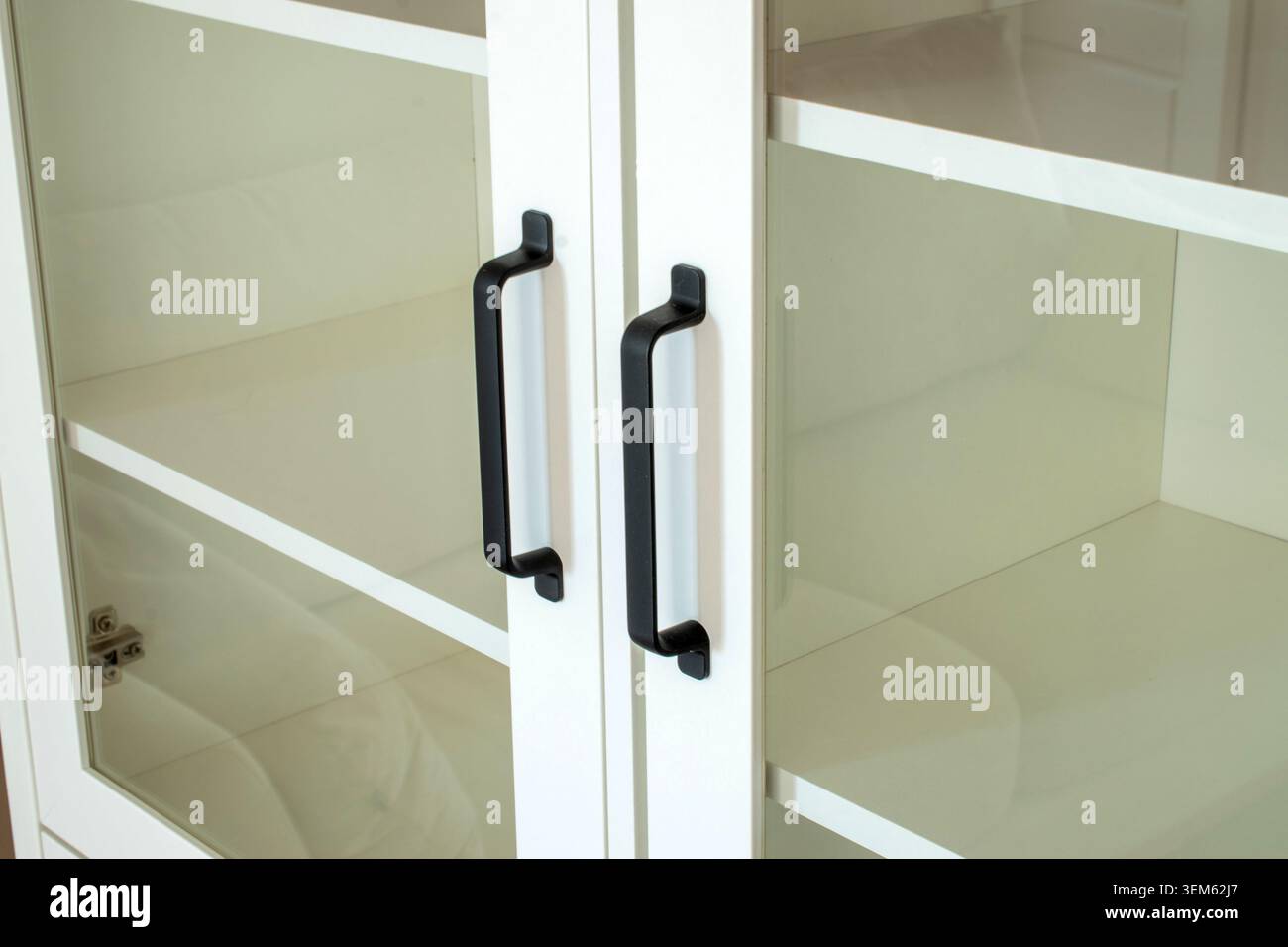 White bookcase with black handles, close-up. Stock Photo