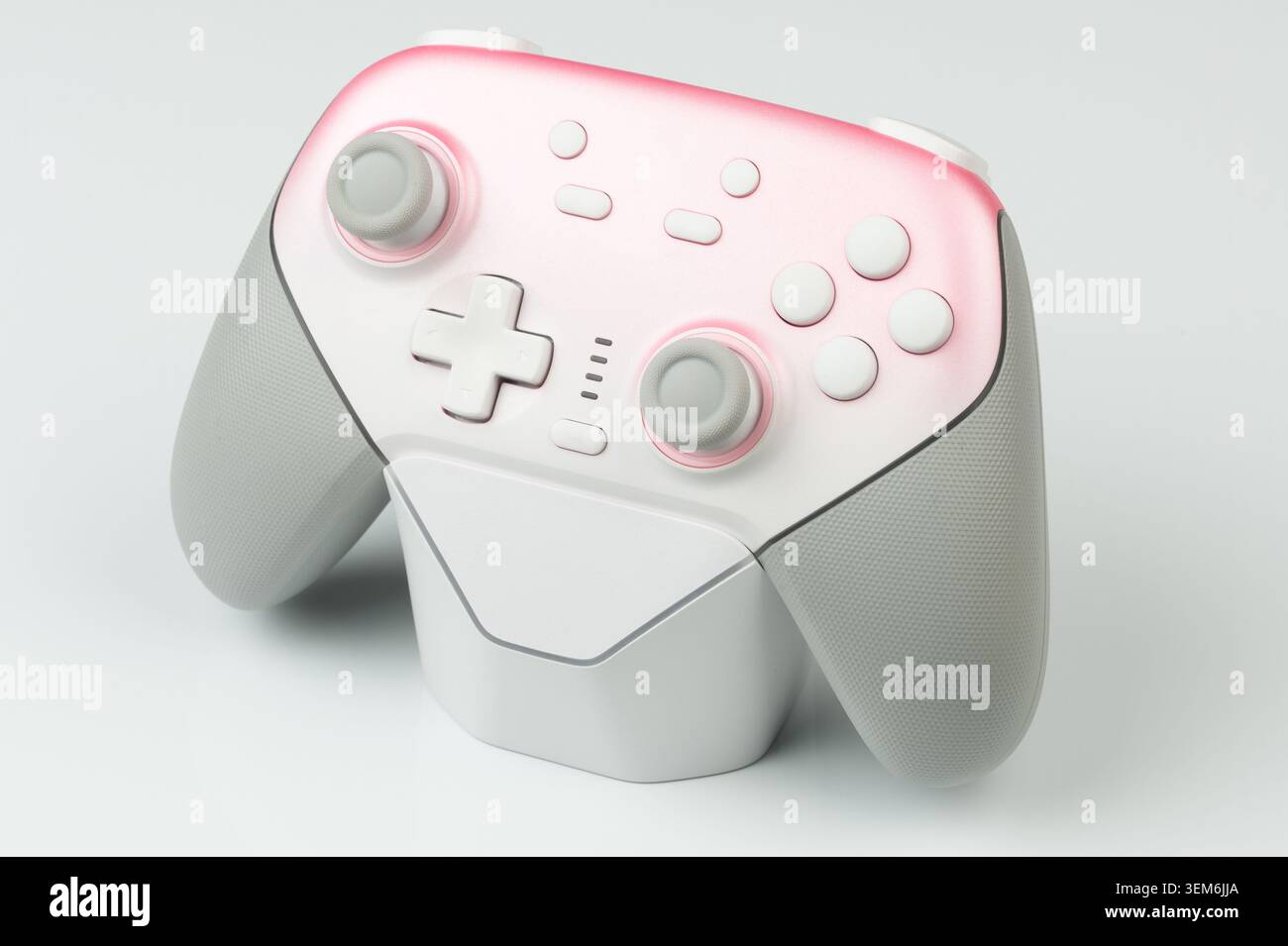 A game controller is placed on a light surface. It shows button layout and ergonomic design elements. Stock Photo