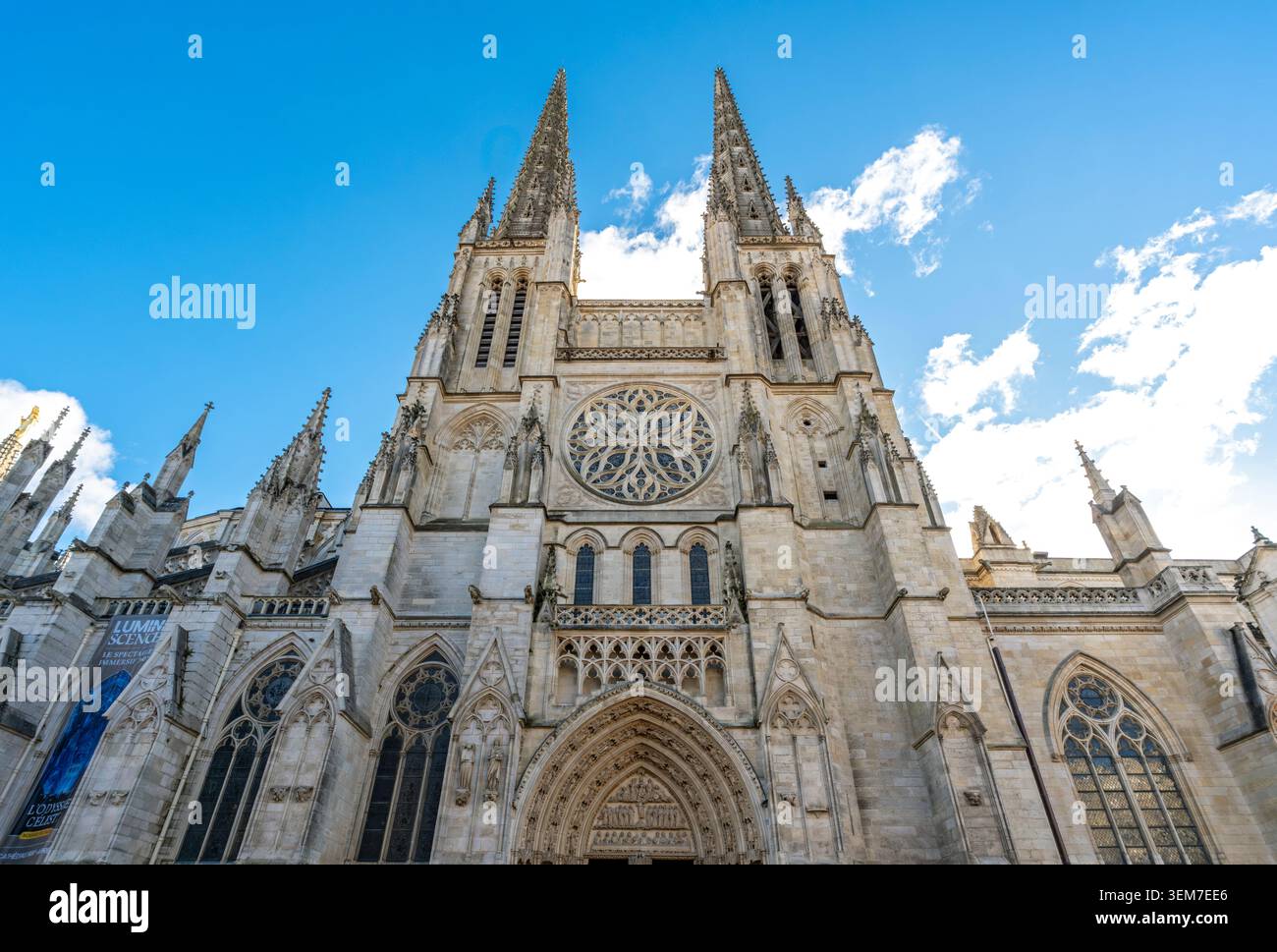 The grand Gothic facade of Cathédrale Saint-André featuring twin spires, an intricate rose window, and a detailed arched entrance, Bordeaux, France Stock Photo