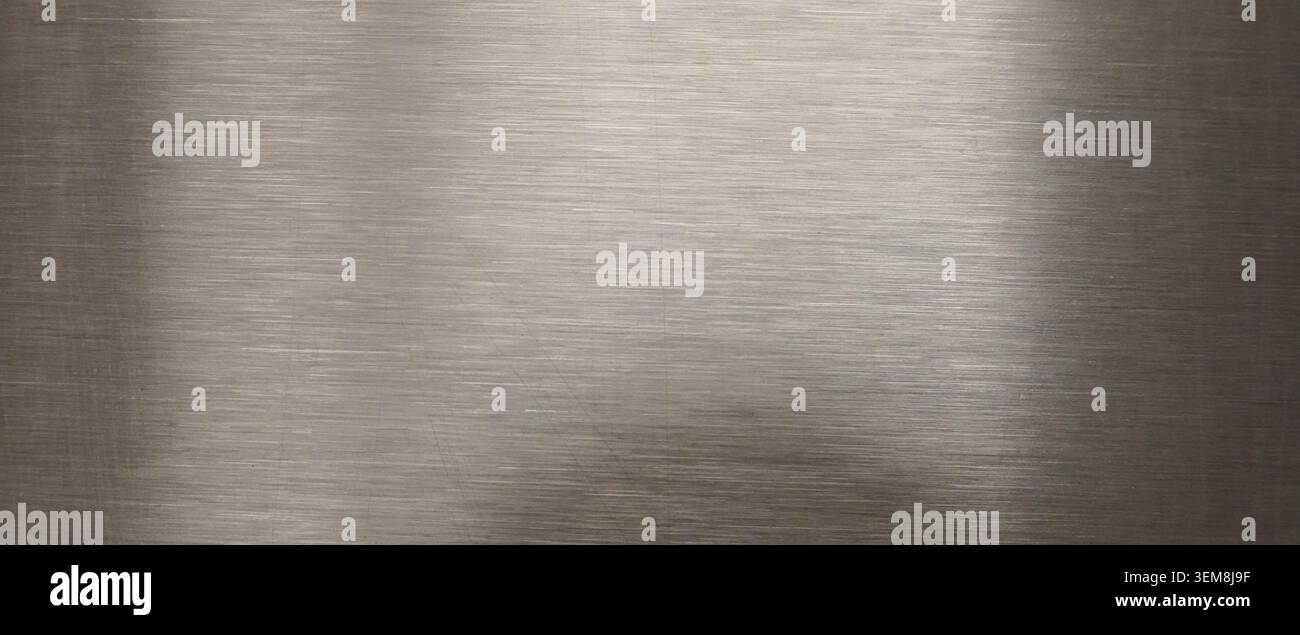 Smooth brushed metal surface with subtle horizontal lines and soft diffused light reflections creating a gradient industrial backdrop Stock Photo