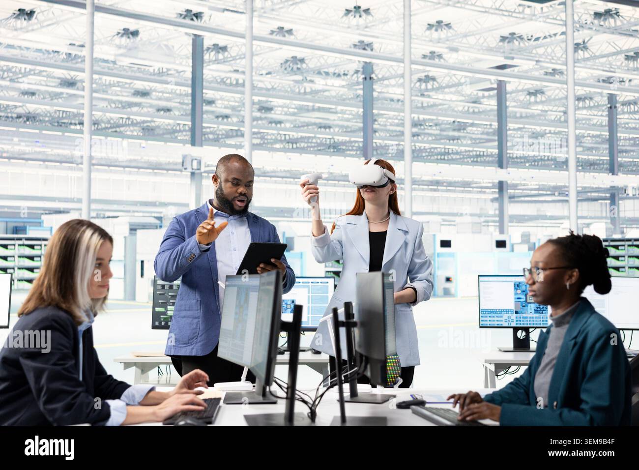 Multiracial team testing microchip electronics prototypes using VR, brainstorming. Teamworking colleagues using virtual reality goggles to upgrade industrial hardware in semiconductors RD laboratory Stock Photo