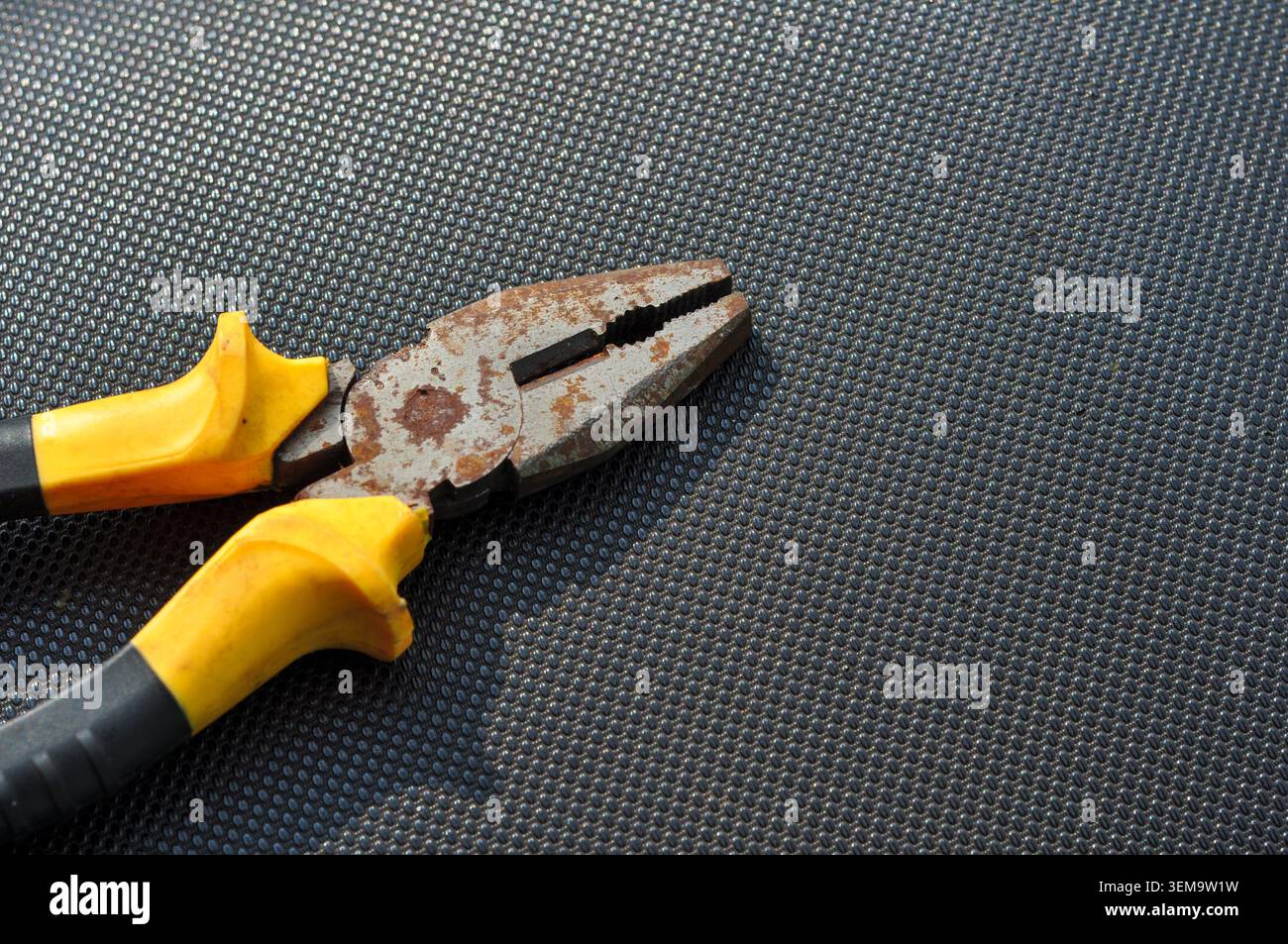Rusty Hand Pliers on Black Textured Background Stock Photo