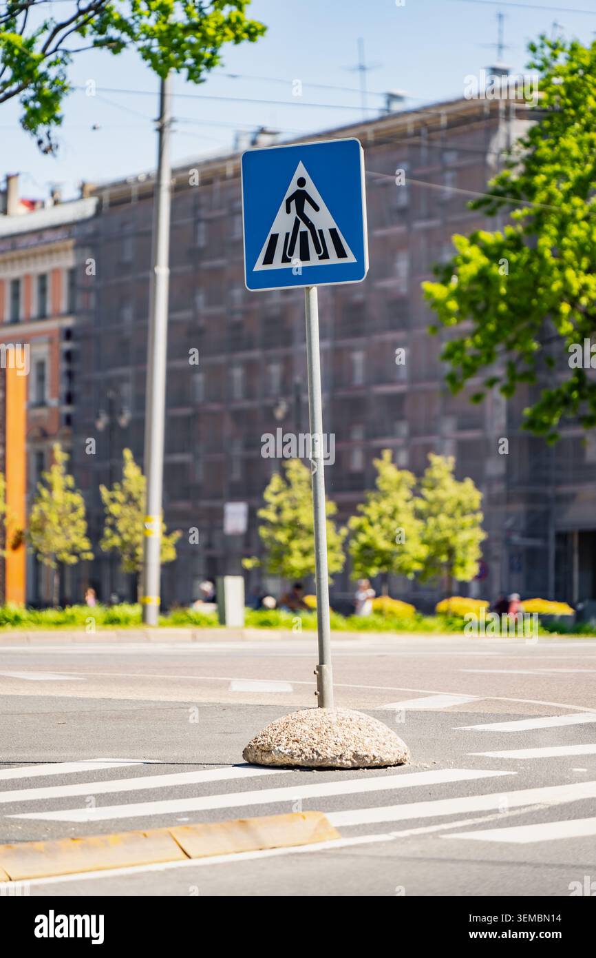 Pedestrian zebra crossing signpost installed on an asphalt street split ...