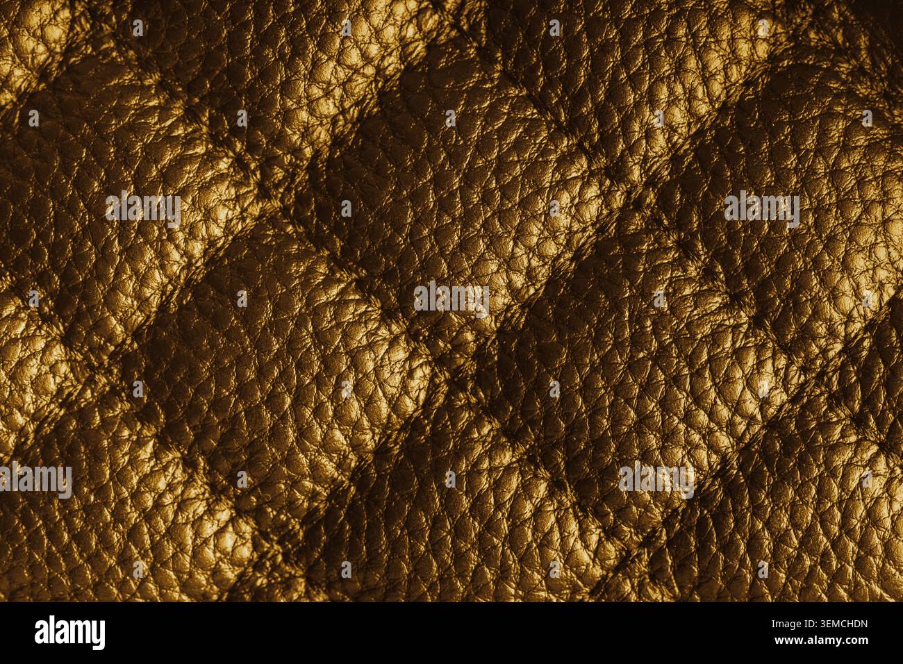 Close up, macro of yellow quilted leather texture with stitched diamond pattern, luxury material surface shining metal effect for fashion, upholstery Stock Photo