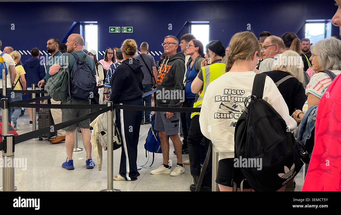People standing in long queue at newcastle airport terminal waiting for check-in security clearance Entry Exit system EES frustration delays passport Stock Photo