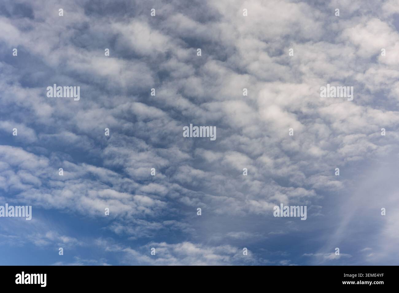 Thick cloud formations with visible blue openings creating contrast in a changing sky Stock Photo