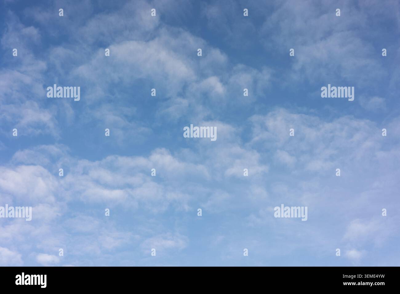 Broken cloud formations drifting across a bright blue summer sky Stock Photo