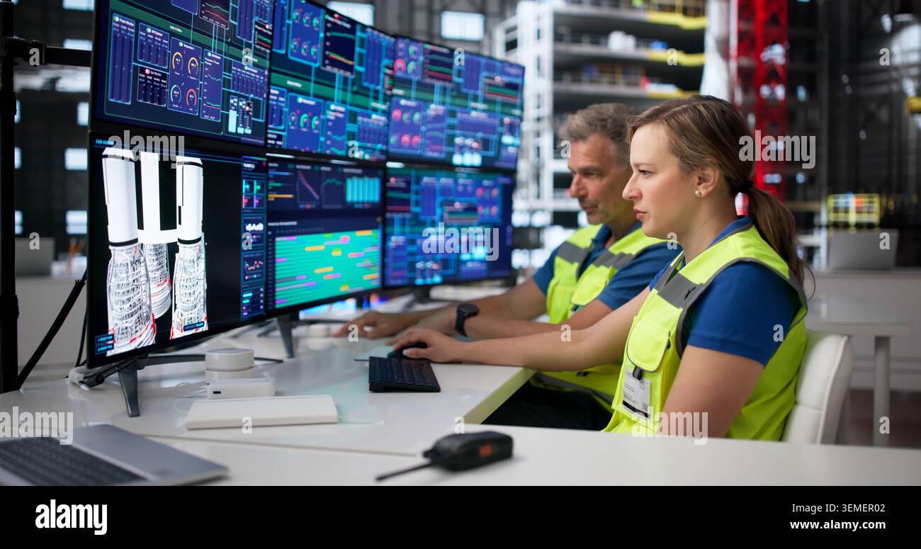 Man And Woman Engineers Discuss Rocket Design Using Desktop Computer Screen. Stock Photo