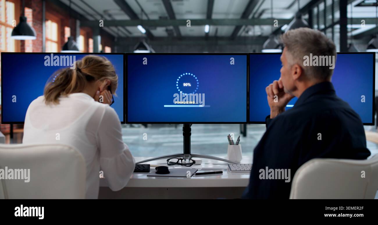 Two IT Specialists Working Together To Update Slow Computer Systems. Stock Photo