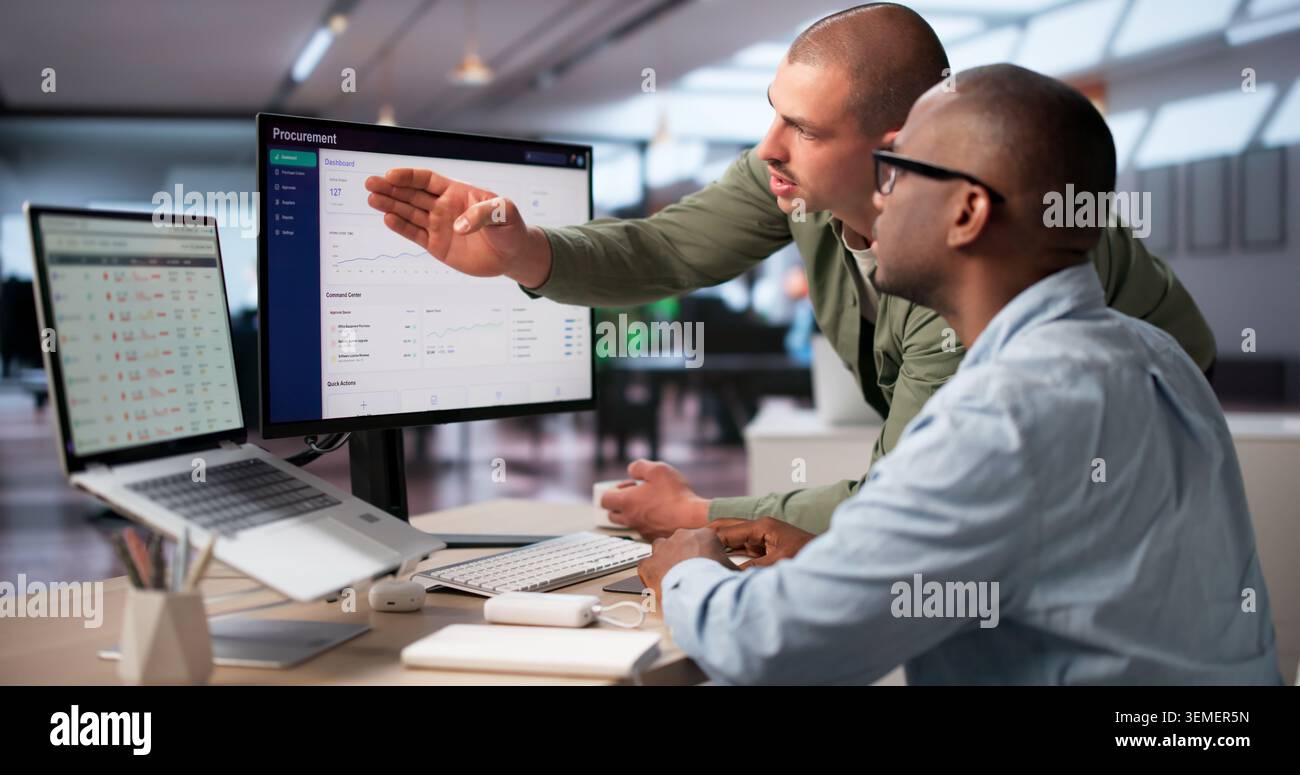Procurement Manager And Colleague Analyze Software Platform To Improve Purchasing Decisions. Stock Photo