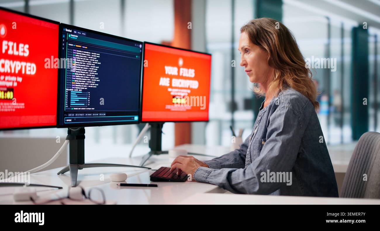 Woman Cybersecurity Analyst Monitors Multiple Screens During Ransomware Attack Response. Stock Photo