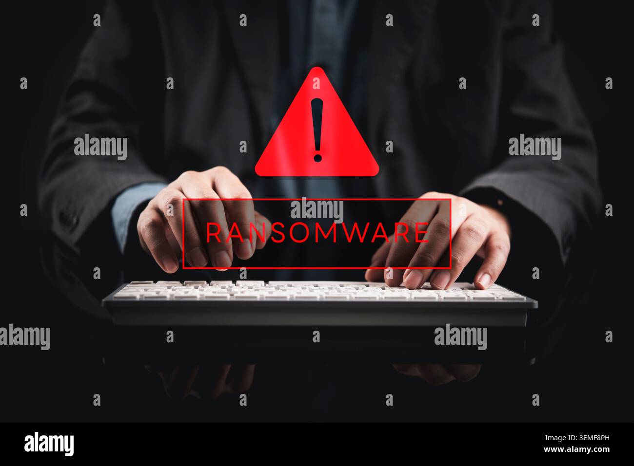 Businessman typing on keyboard with red ransomware alert hologram. Cyber security concept showing malware attack, data breach, and system encryption w Stock Photo