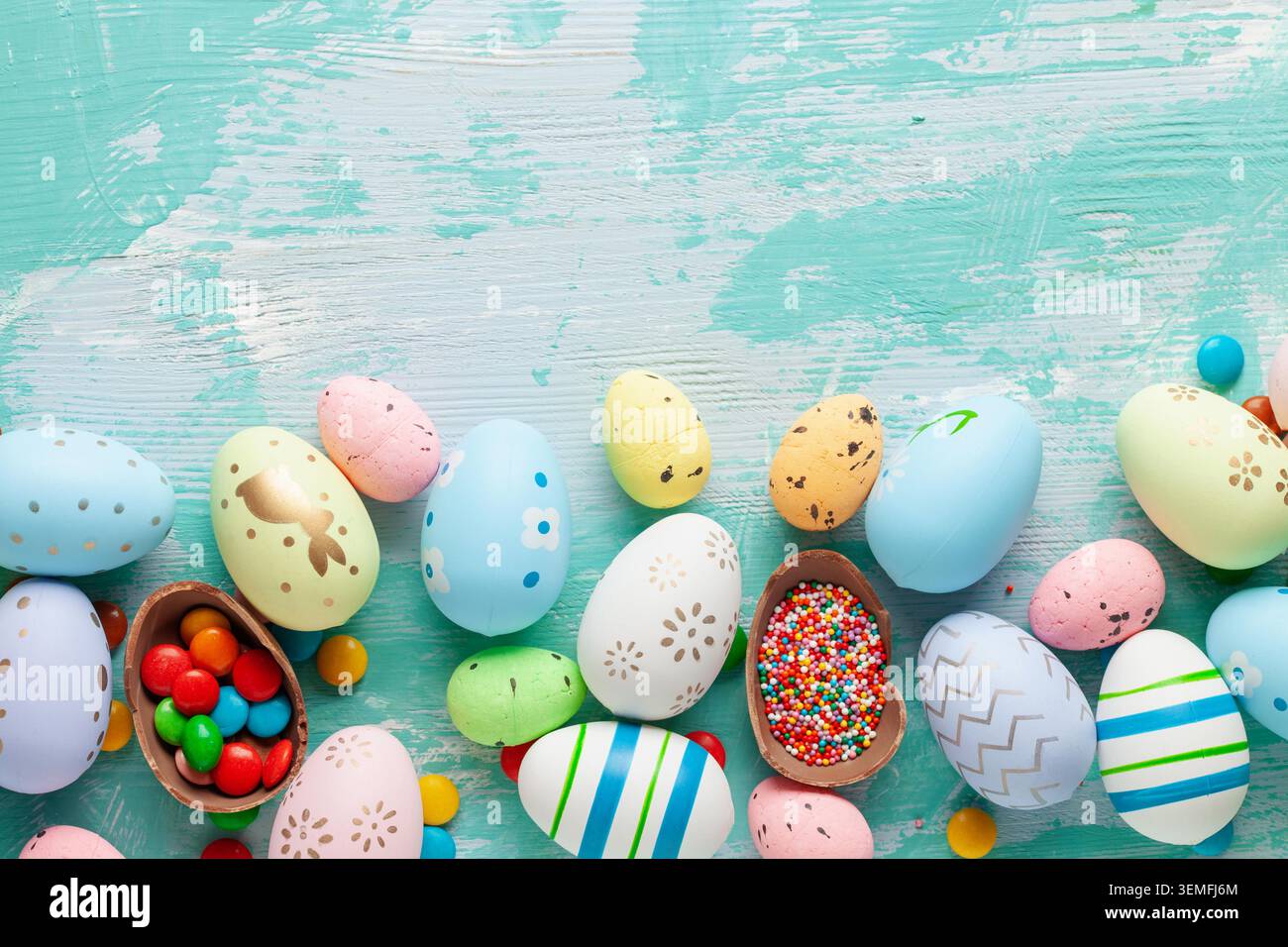 Colorful Easter Egg bottom border over a blue wooden background. Stock Photo