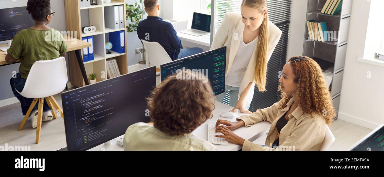 Diverse developers collaborating on code in a startup office during team meeting Stock Photo