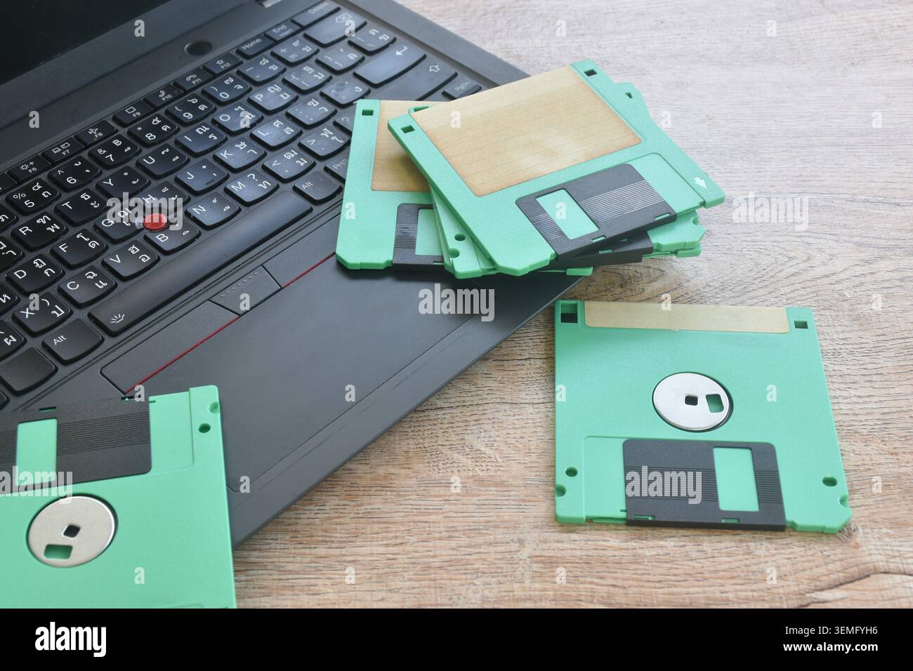 floppy disk old technology for saving data arranging with laptop computer on table Stock Photo