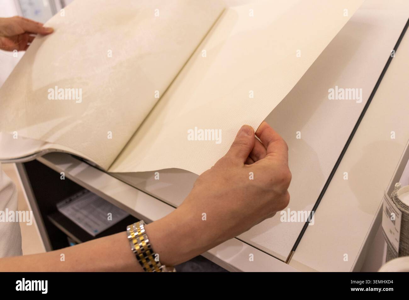Customer Browsing Wallpaper Catalog Book in Modern Interior Design Showroom Stock Photo