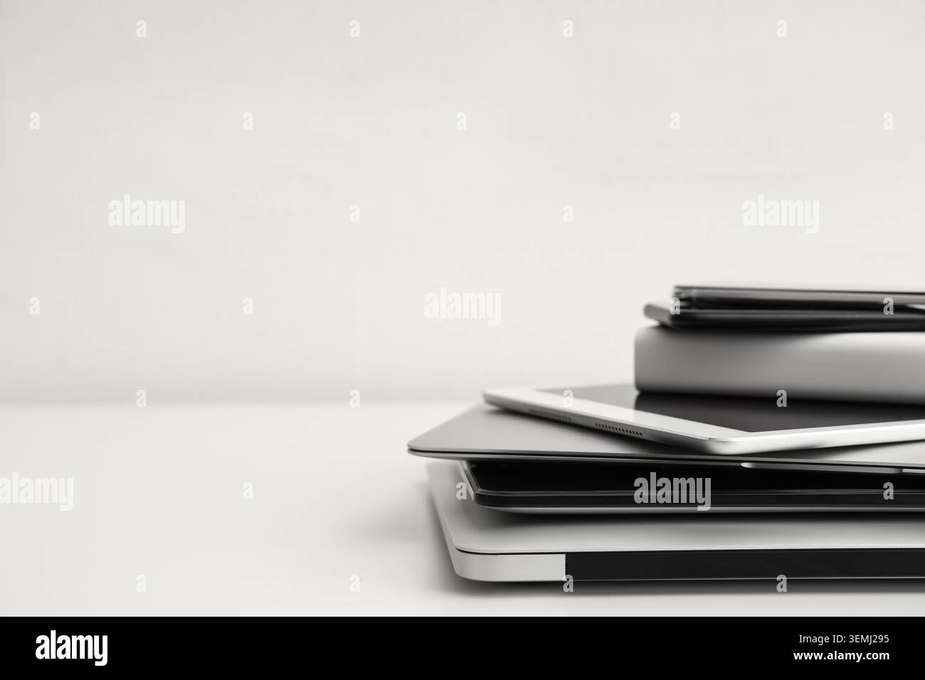 Stack of different modern gadgets on light background Stock Photo