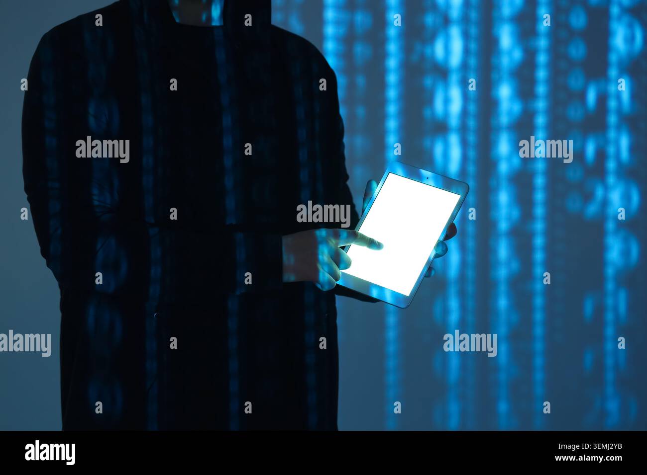 Hacker using tablet computer and projection of programming code in dark room, closeup Stock Photo