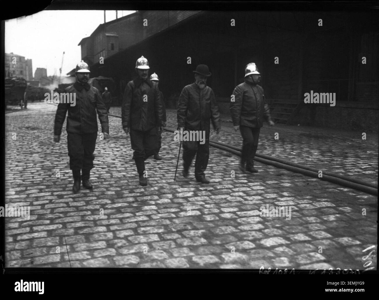 A press photograph records Louis Lépine in the company of firefighters during a fire at the premises of the Compagnie générale des voitures de Paris in the Montmartre district on 14 May 1908. Stock Photo