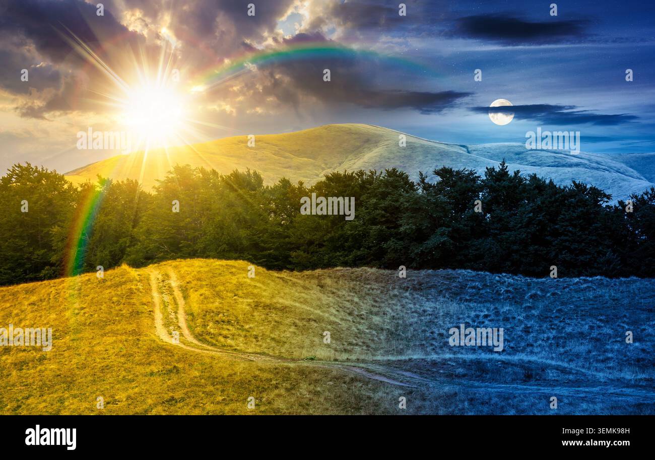 dirt road through grassy hills. day meet night. mountain landscape with beech forest along the path. sun and moon in harmony over remote countryside. Stock Photo