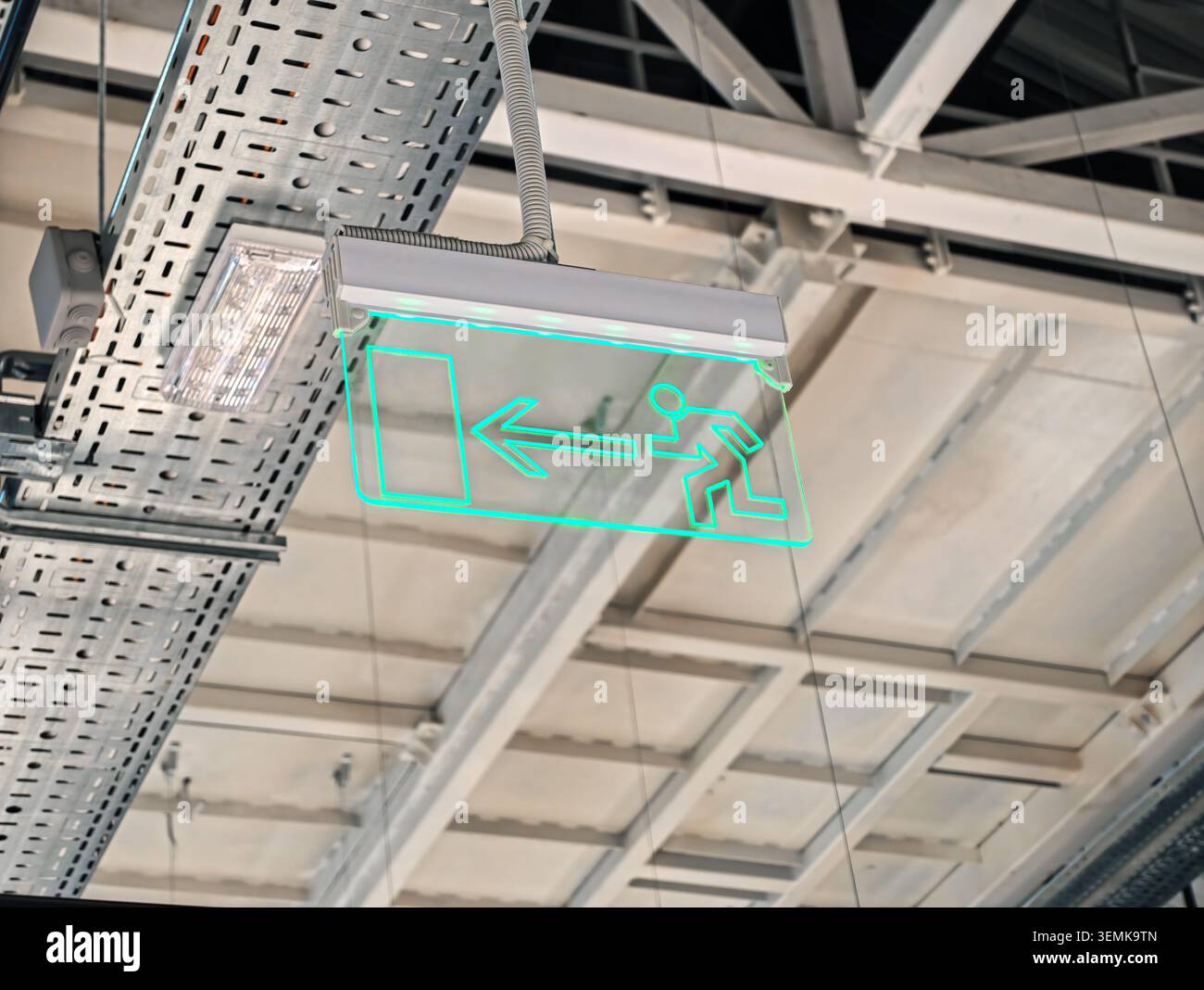Green emergency exit sign with running man icon and arrow inside modern ...