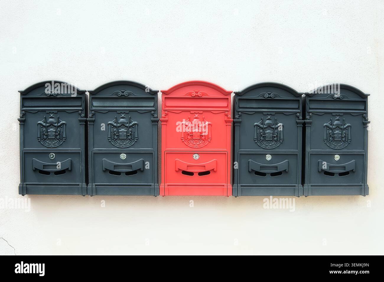 Old-fashioned black and red mailboxes on the wall Stock Photo