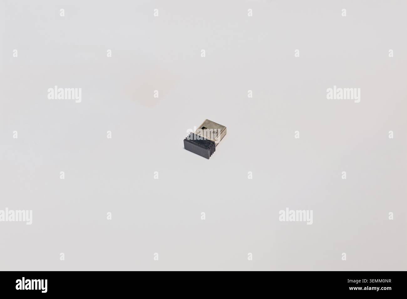 Small black and silver USB wireless dongle receiver for computer mouse on white background Stock Photo